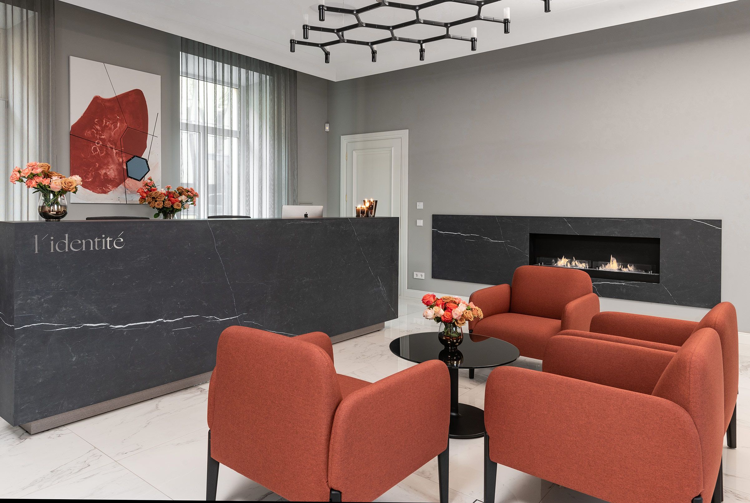 Reception of the L'identité clinic – marble, flowers and terracotta armchairs